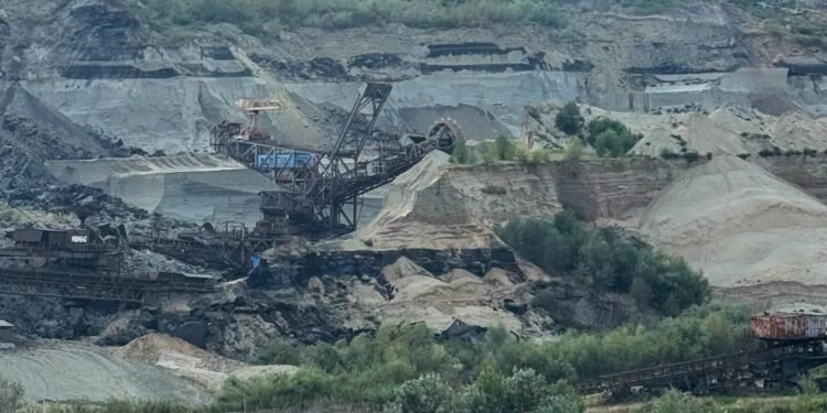 Panică în carieră. Un milion de metri cubi de pământ au luat-o la vale și au înghițit un excavator uriaș